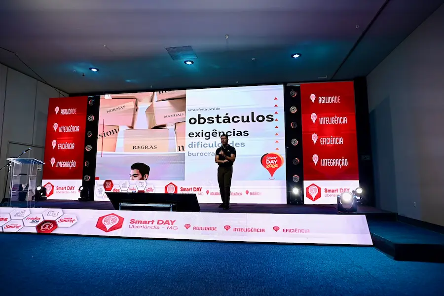 Palestrante apresentando conteúdo sobre superação de obstáculos e eficiência operacional em evento corporativo Smart Day, realizado em Uberlândia-MG, diante de uma plateia de profissionais e gestores.